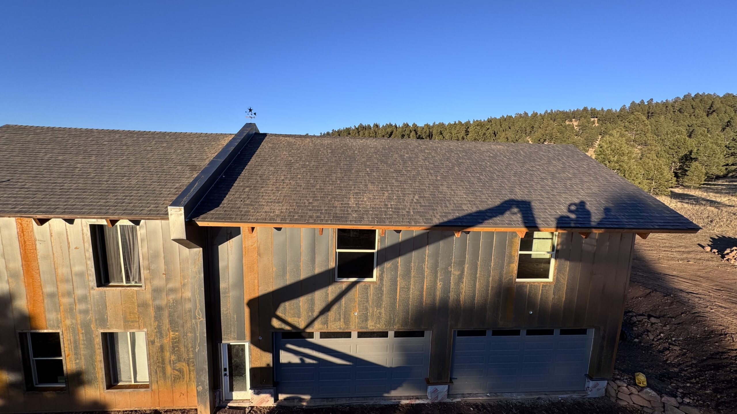 Home with stone arch entry and wood-tone metal siding combination